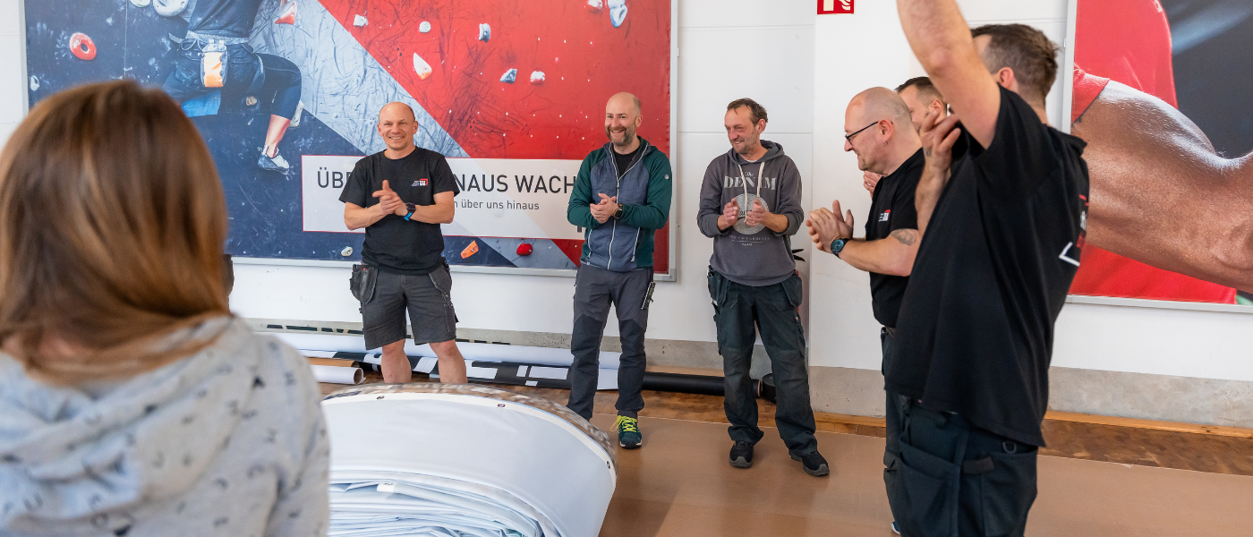 mehrere Personen stehen in einem Kreis und klatschen