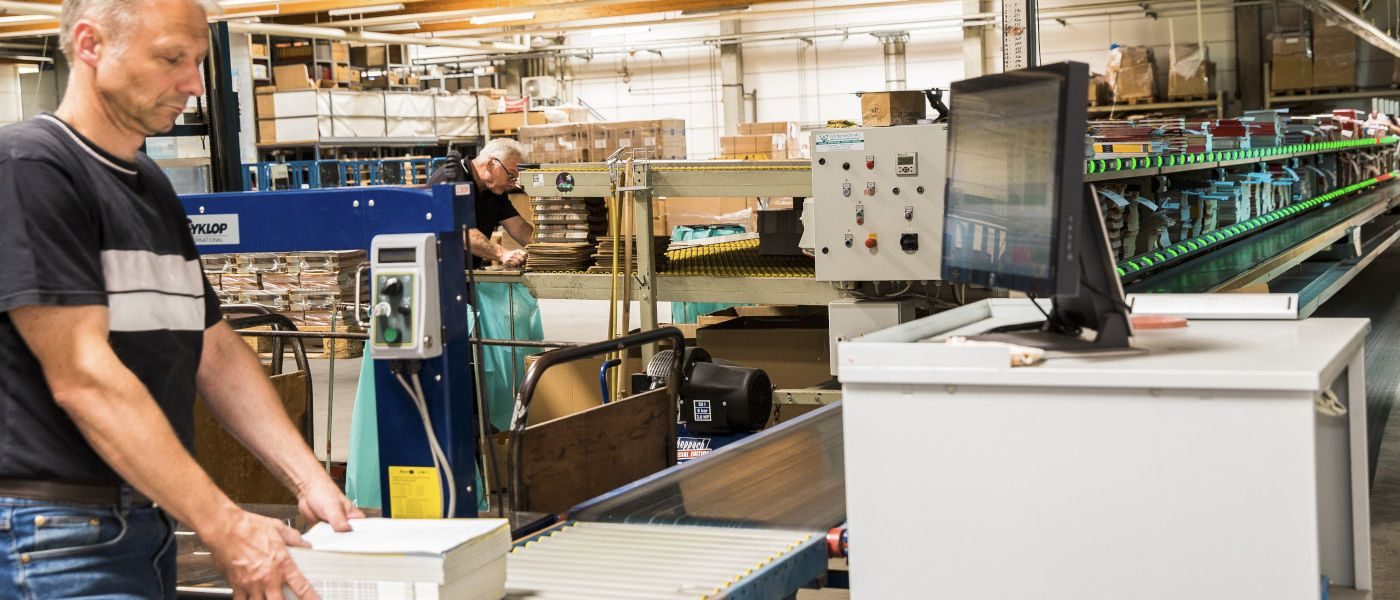 ein Mann steht vor einem Gerät mit Fließband