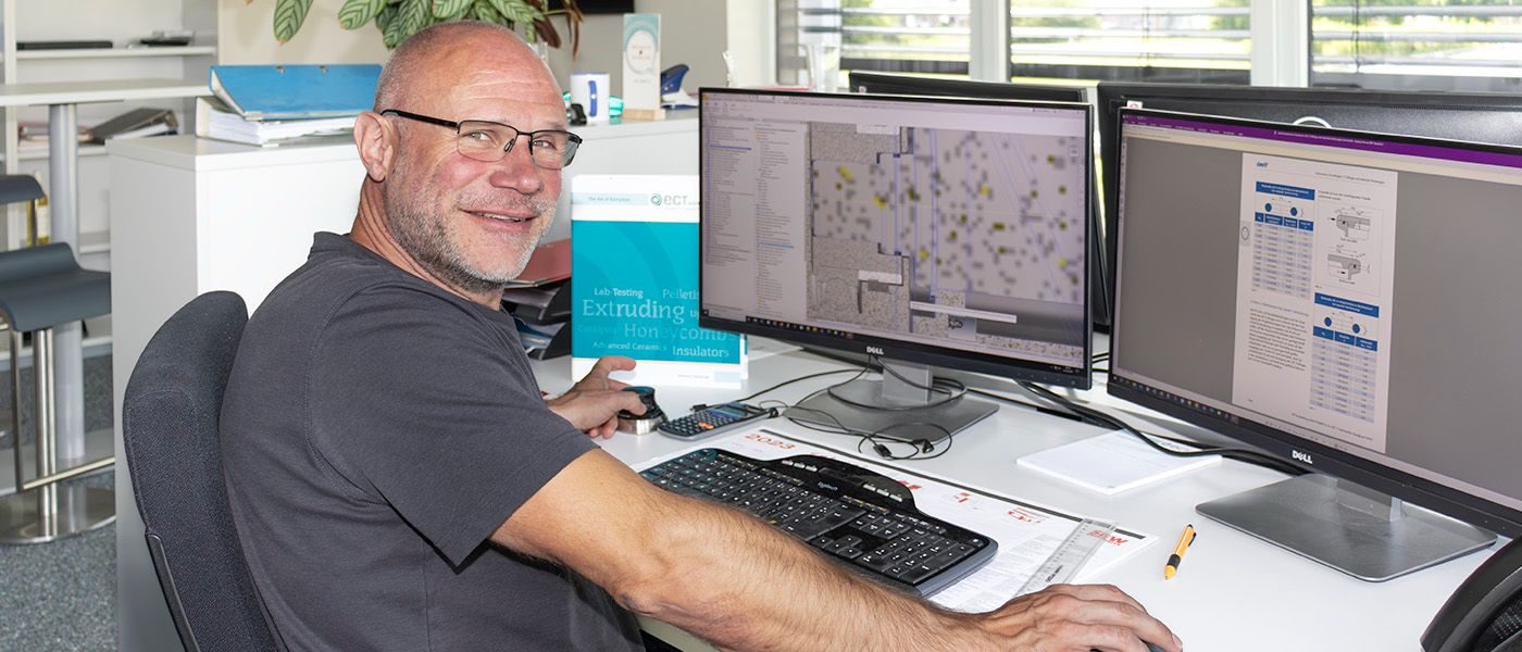 ein Mann sitzt an einem Schreibtisch mit Computern